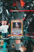 Mewtwo Pokémon card in acrylic protective display case surrounded by anime figures