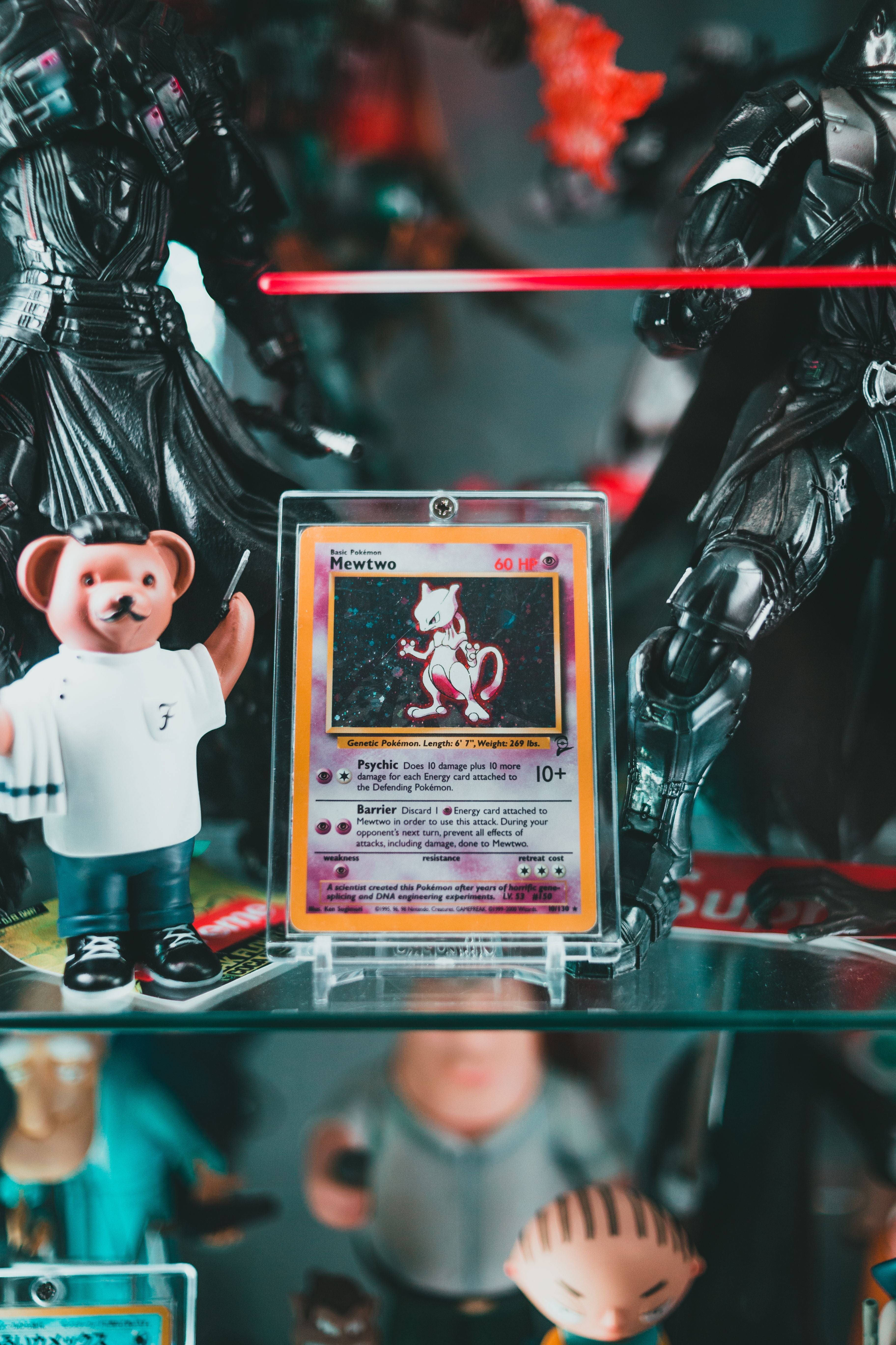 Mewtwo Pokémon card in acrylic protective display case surrounded by anime figures